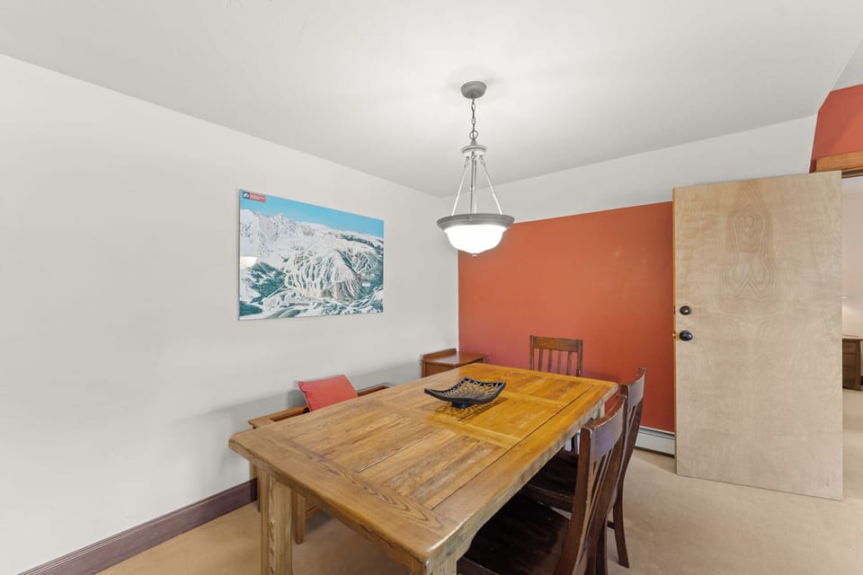 Gather around your beautiful wooden dining table for memorable meals in this warm, inviting space with vibrant accents.