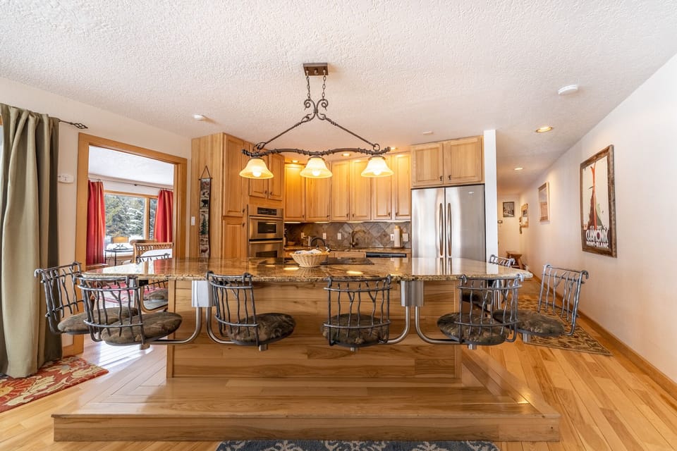 Gather around your gourmet kitchen's granite island for memorable meals, surrounded by warm wood cabinets and stunning mountain views through picture windows.