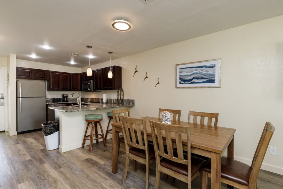 Your open kitchen and dining area blends modern convenience with coastal charm, perfect for preparing meals and gathering with loved ones.