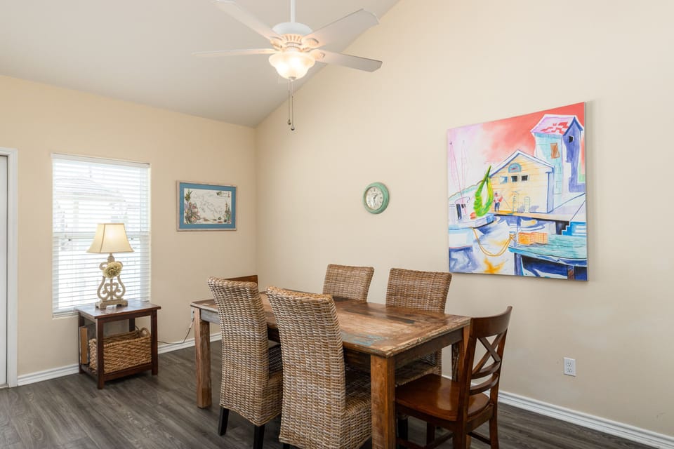 Your spacious dining room welcomes family meals with comfortable seating for six and charming coastal artwork overhead.