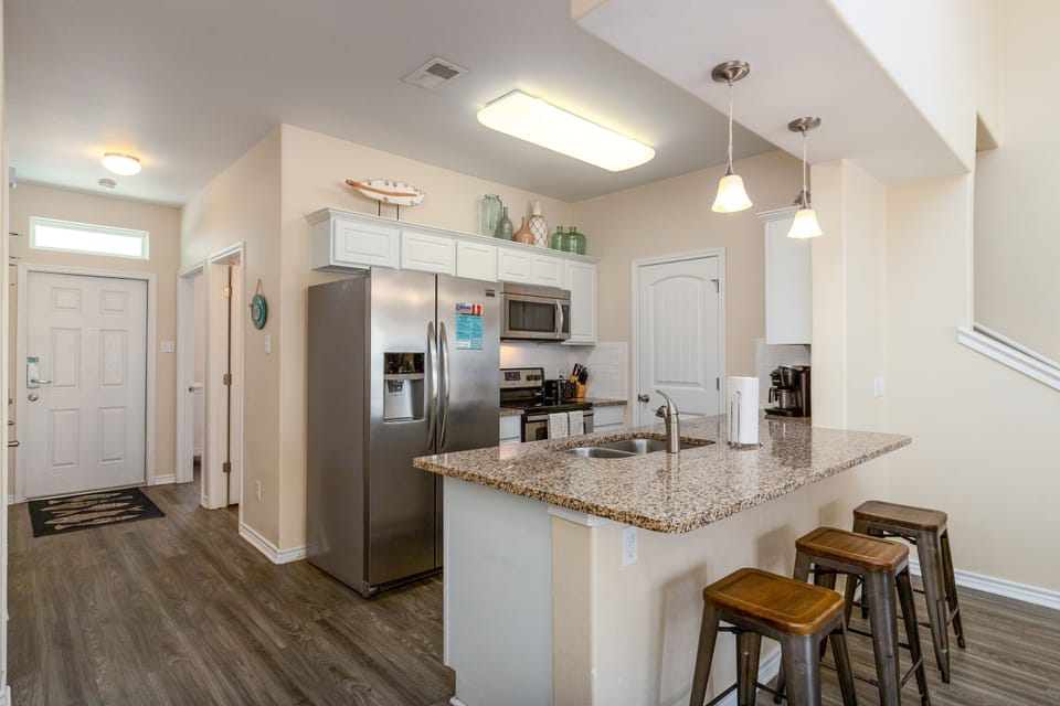 Your spacious kitchen features granite counters, stainless appliances, and a breakfast bar perfect for morning coffee or casual meals.