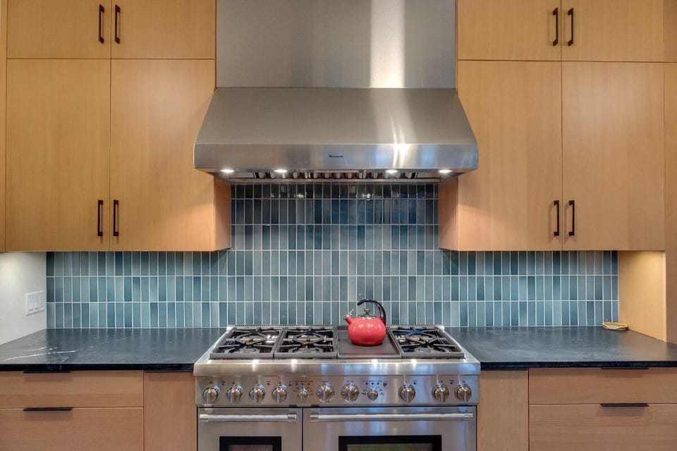 The modern kitchen is complete with a 6 burner Thermador range, farmhouse sink and soapstone counter tops.