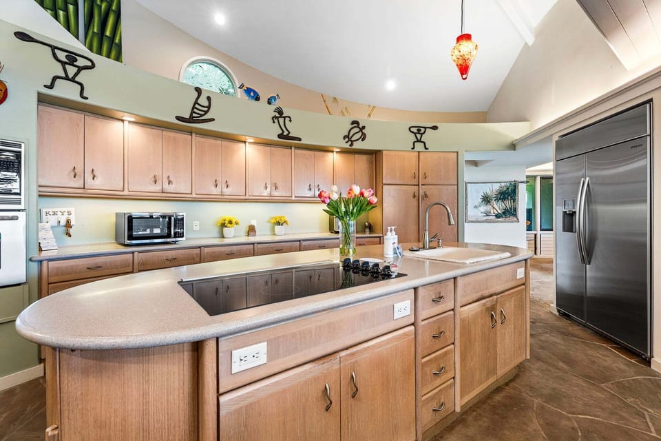 Chef's Kitchen – Unique circular layout with high ceilings, large island seating, modern appliances, and ample prep space