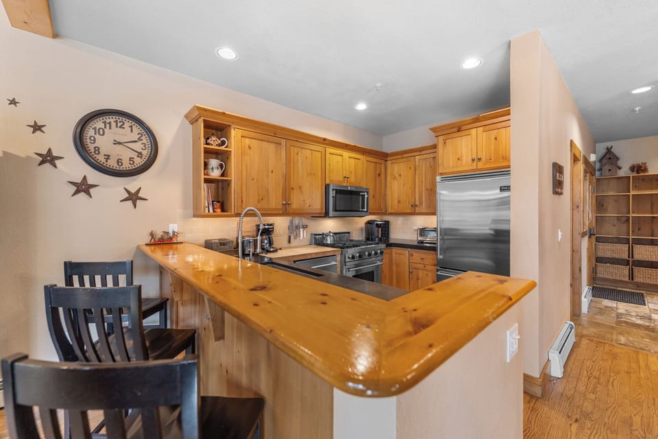 Step into your fully equipped kitchen featuring warm wood cabinetry, granite counters, and stainless steel appliances—perfect for preparing memorable meals.