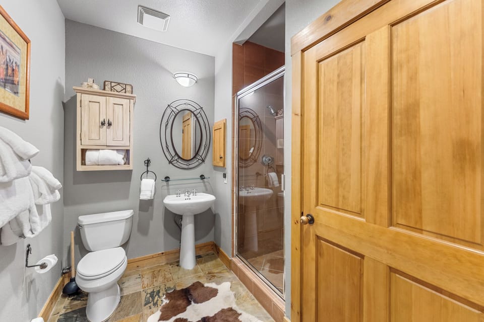 Step into your private bathroom sanctuary with rustic charm, featuring a spacious walk-in shower and cozy nautical touches.