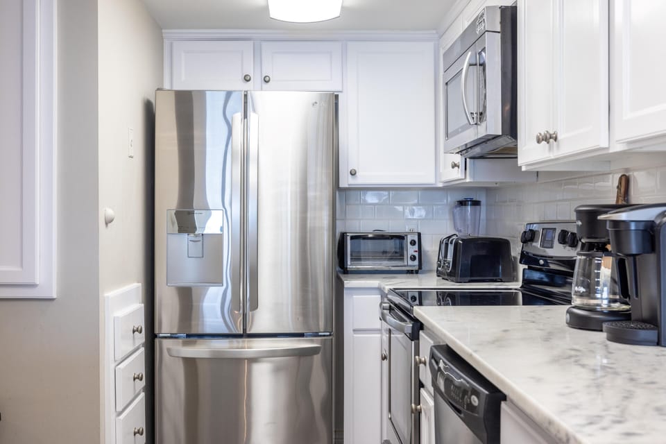 Kitchen - Elevate your culinary experience in a fully stocked kitchen featuring stainless appliances, generous cabinet space, and sleek countertops—ideal for preparing meals.