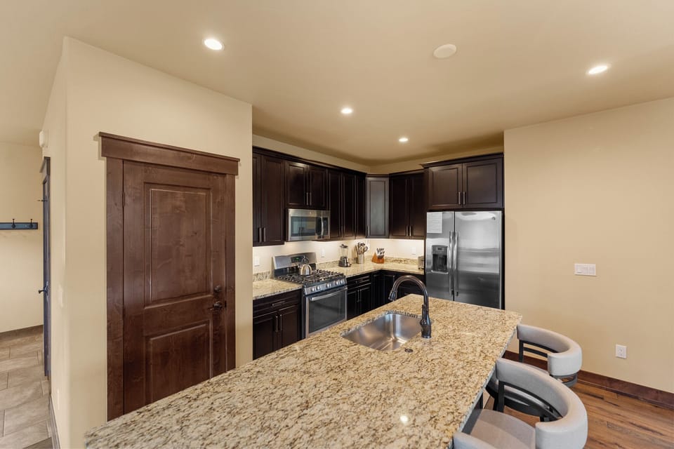 Your fully equipped kitchen features granite countertops, stainless steel appliances, and a breakfast bar where you can prepare meals and gather.
