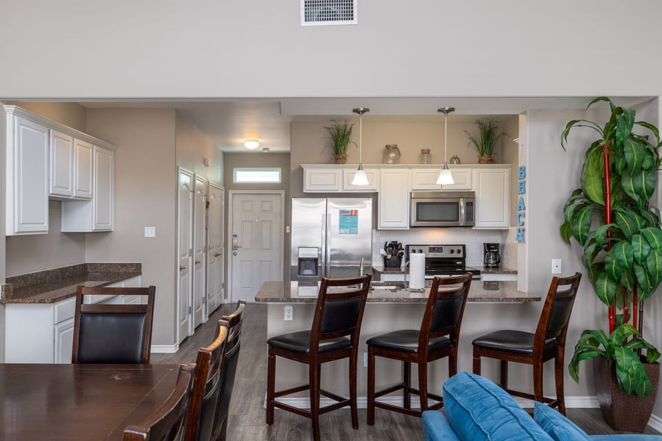 Your open kitchen features stainless appliances, granite counters, and breakfast bar seating for memorable meals together.