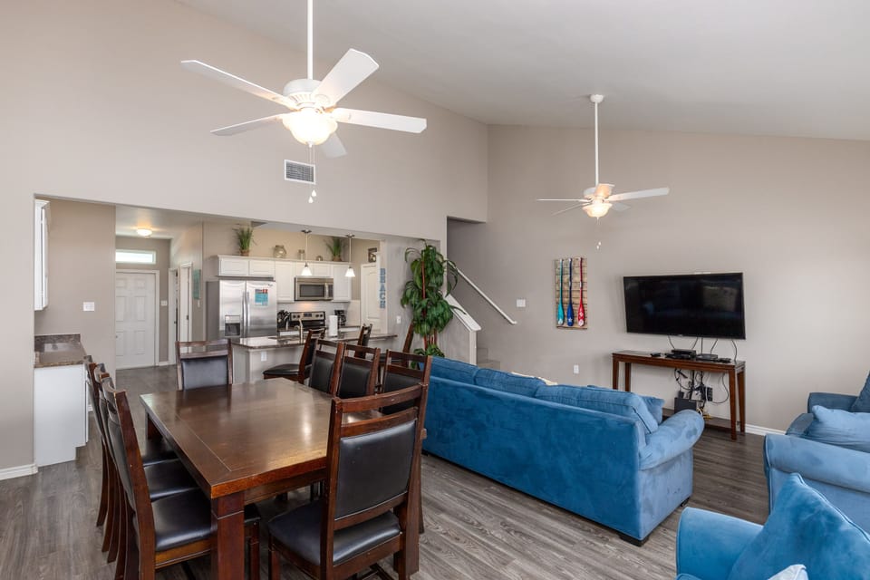 Relax in your spacious open-plan living area with comfortable blue sofas, dining for eight, and a fully equipped kitchen.