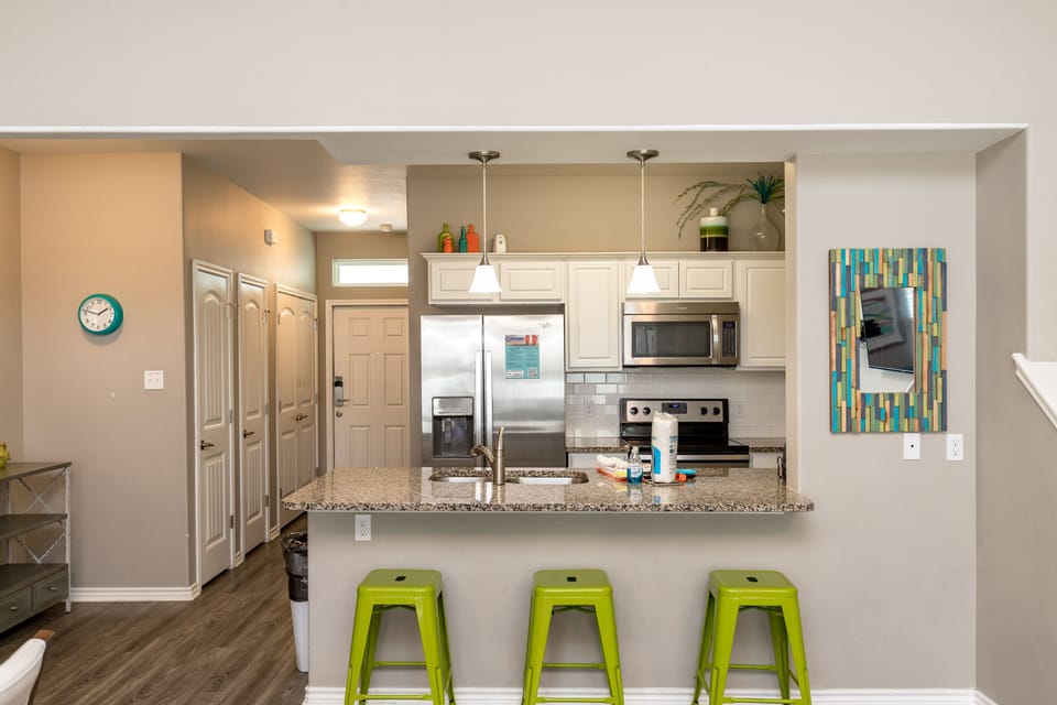 Your modern kitchen features granite countertops, stainless appliances, and a breakfast bar perfect for morning coffee or casual meals.