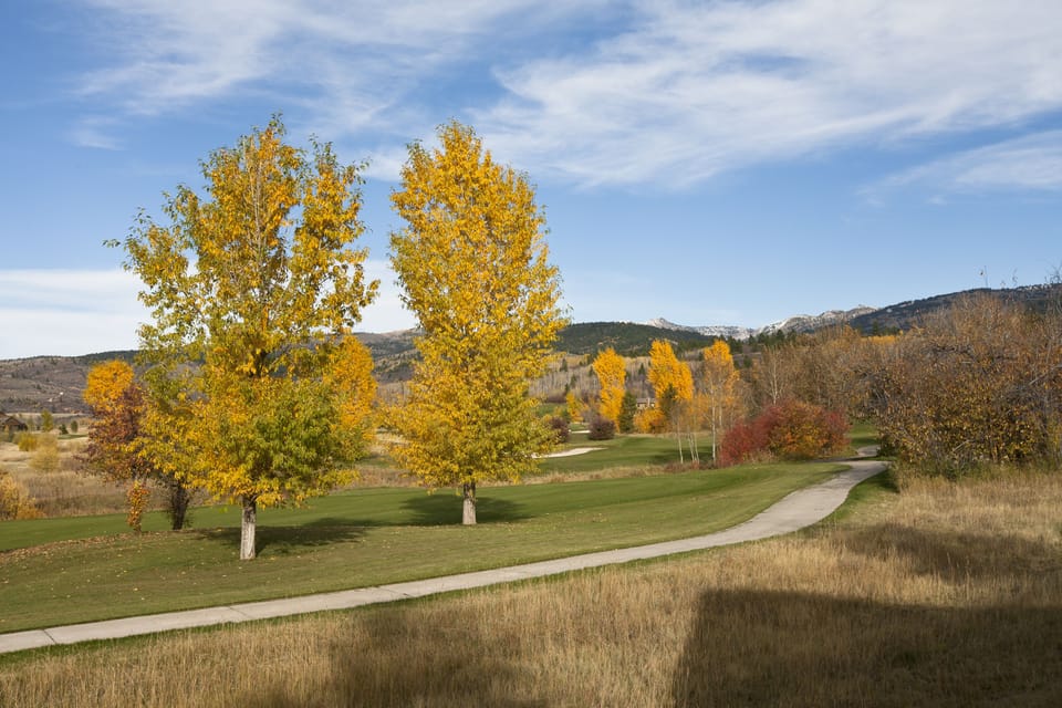 Step outside to discover your breathtaking autumn paradise, where golden aspens frame rolling fairways and mountain vistas stretch endlessly before you - your perfect escape awaits.