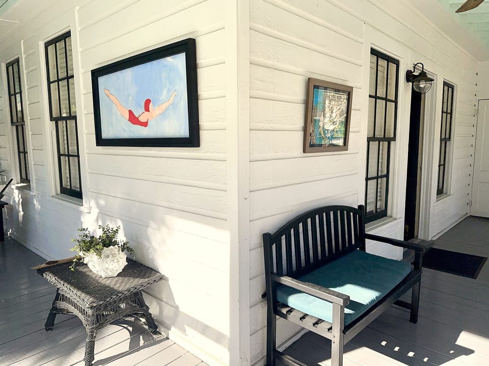 Screened porch - This roomy screened porch wraps around two sides of the house and is filled with comfy seating and coastal art. It’s more than a porch....it’s an outdoor living room with Tybee charm.