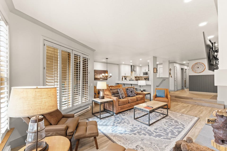 Unwind in your spacious living area with leather seating, modern fireplace, and open-concept design flowing into the fully equipped kitchen.