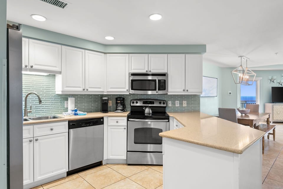 Your fully equipped kitchen awaits with modern stainless steel appliances and a spacious island for cooking memorable vacation meals together.