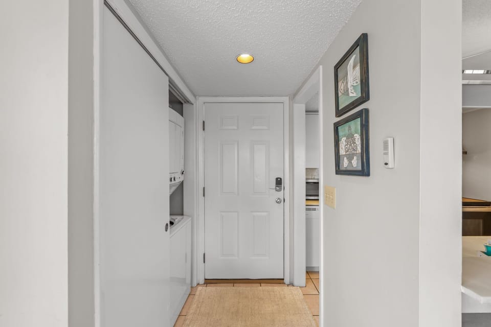 Step into your welcoming entryway, where soft lighting and coastal artwork greet you, setting a relaxed tone the moment you arrive at your coastal retreat.