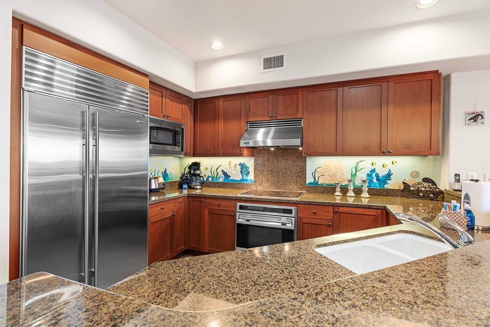 Massive stainless steel fridge, microwave, and oven range in the kitchen of this Waikoloa Hawai'i vacation rental.