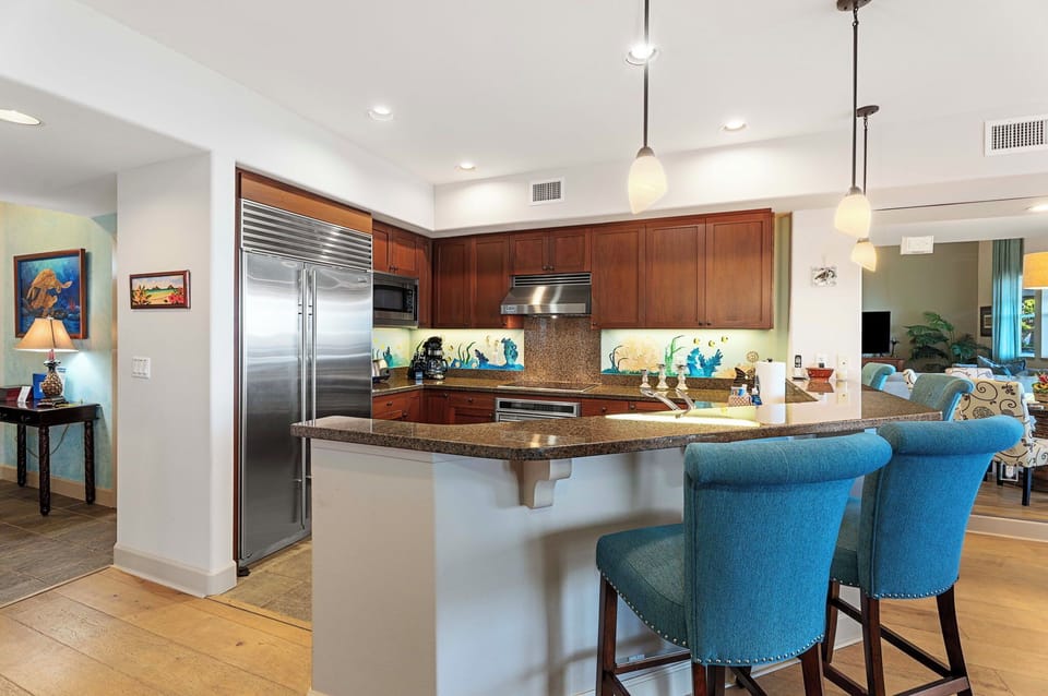 Fully equipped kitchen breakfast counter and stainless steel appliances.