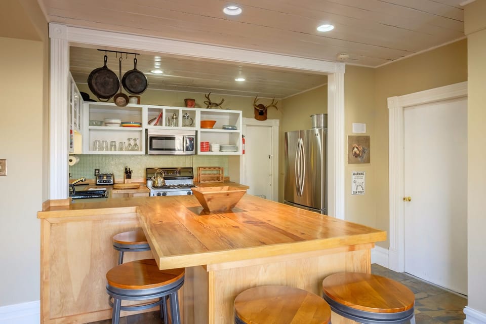 The dining area is open to the kitchen and living room. The table sits six and there are four more stools at the counter.