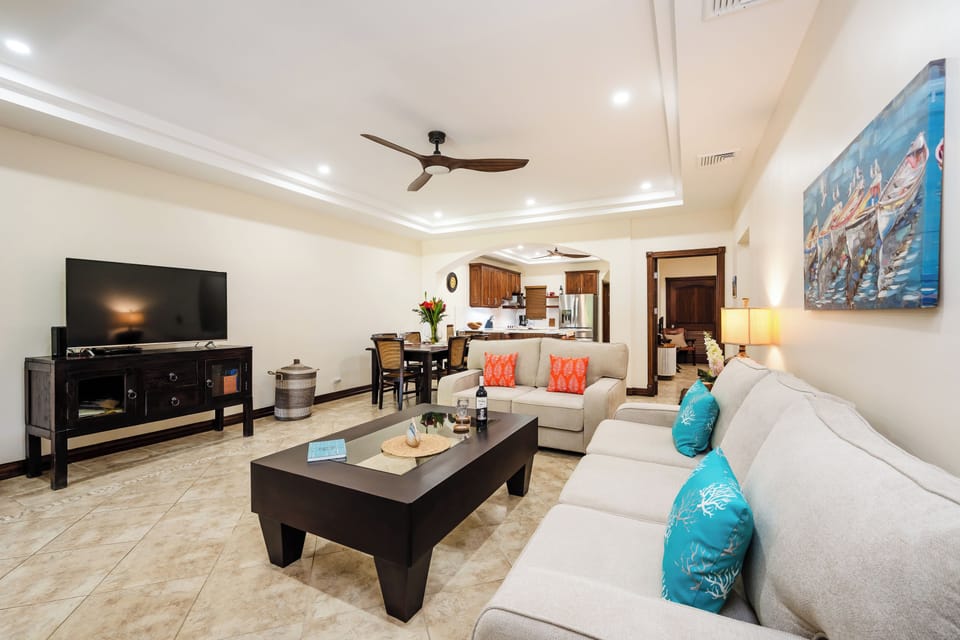 Open living room at Horizontes del Mar, Playa Langosta. Tropical design flows to dining and kitchen. Costa Rica beachfront condo near Tamarindo, perfect for family vacations, surf trips, and ocean breeze evenings just steps from Langosta Beach.