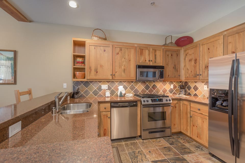 Your fully equipped kitchen features granite countertops, stainless steel appliances, and warm wood cabinets for memorable meal preparation.