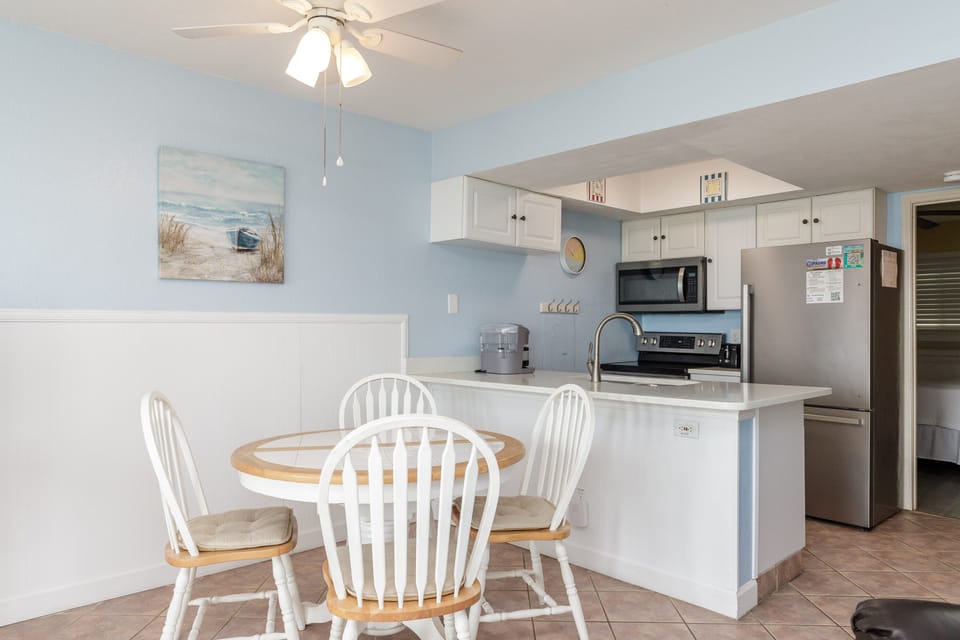 Your bright, coastal-themed kitchen invites you to start each day with coffee and ocean views from your dining table.