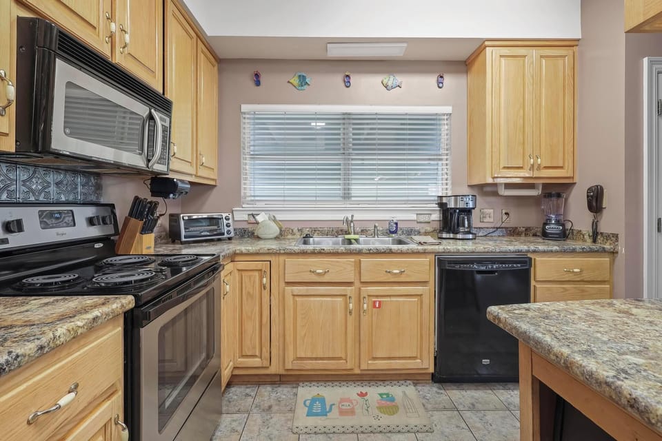 Kitchen - The large, open kitchen features stainless appliances, which include a dishwasher, electric oven, built in microwave, and refrigerator with ice maker.