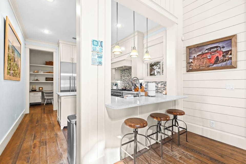 Your modern farmhouse kitchen features white cabinetry, granite counters, and a breakfast bar perfect for morning coffee.