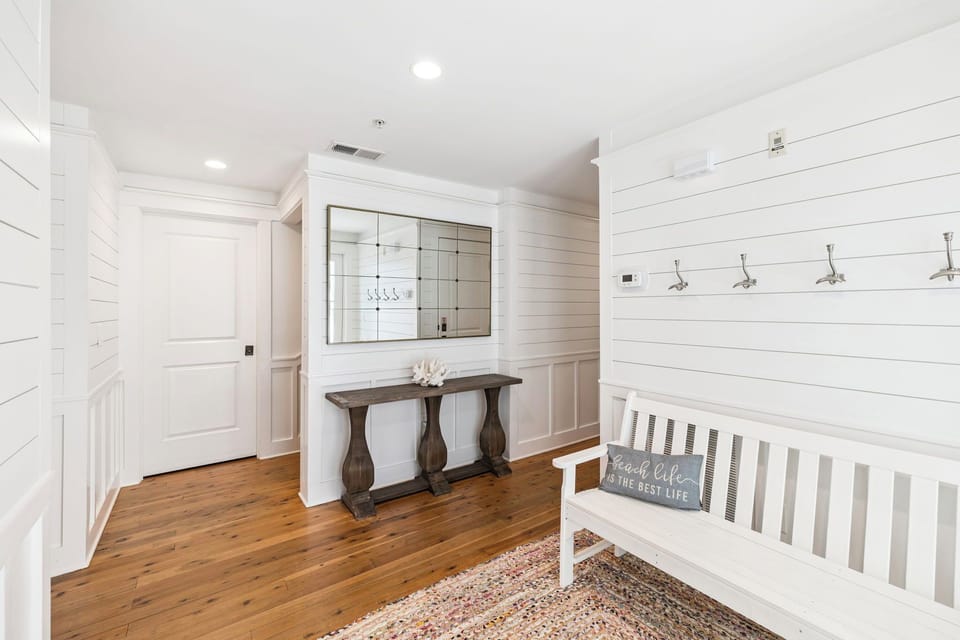 Your welcoming entryway features shiplap walls, warm hardwood floors, and a rustic console table where you can drop your keys after a perfect day.