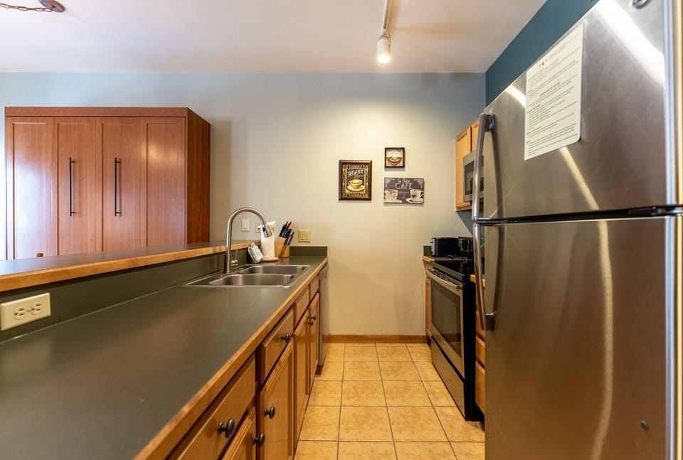Your fully equipped kitchen awaits with stainless steel appliances, granite countertops, and warm wood cabinetry for easy meal preparation.
