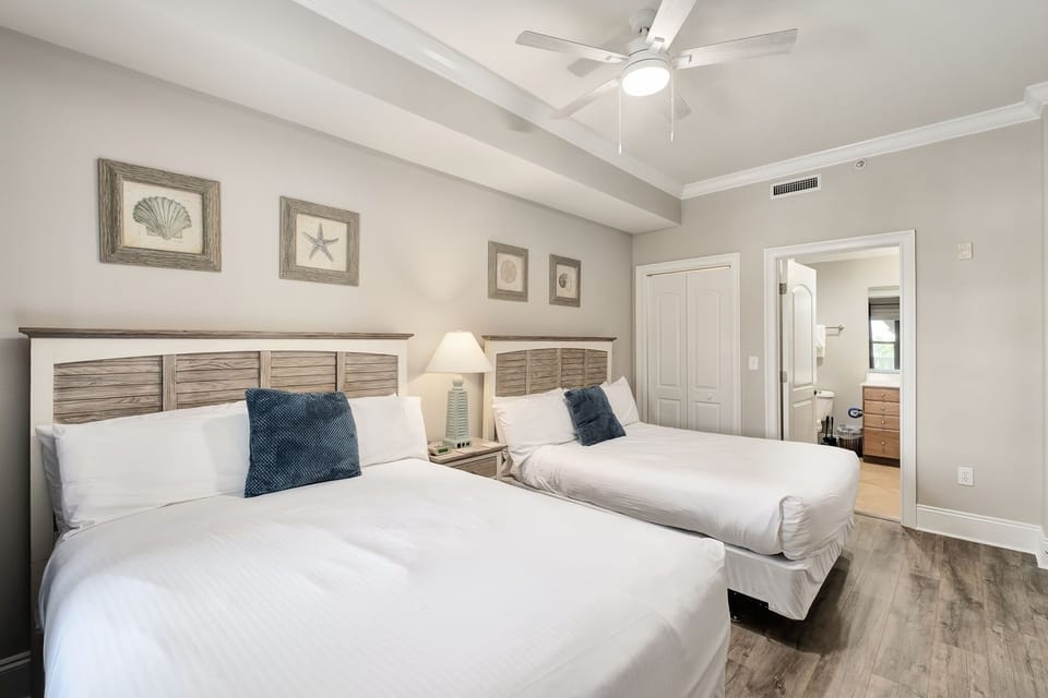 Sink into crisp linens on two plush beds, each promising restful nights beneath a gentle ceiling fan. Coastal touches and soft lighting create your peaceful retreat after beachside adventures.