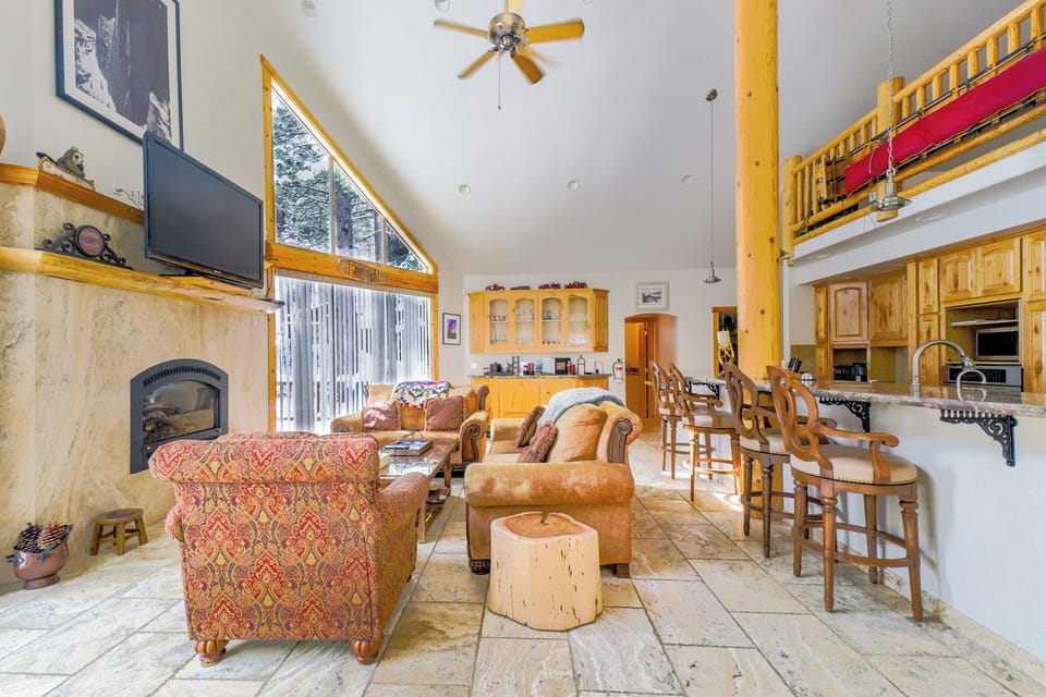 Spacious and inviting living area with high ceilings, large windows, and a cozy seating arrangement, perfect for family gatherings.