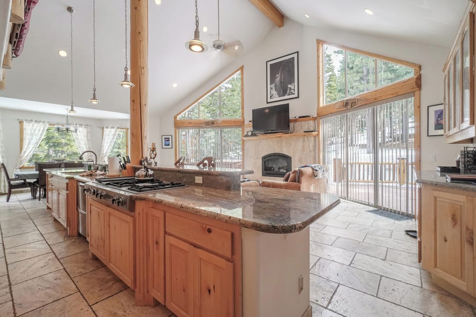 Gourmet kitchen with granite countertops, stainless steel appliances, and large windows offering beautiful views of the surrounding nature.