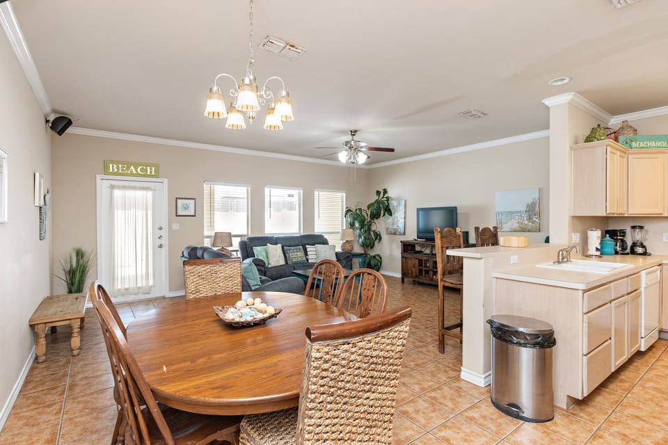 Gather around the inviting dining table while your chef prepares meals in the open kitchen, all with coastal charm throughout.