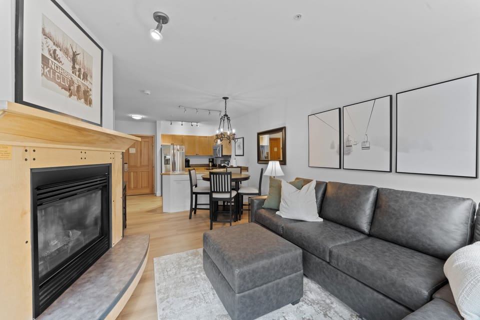Unwind in your modern living space with cozy fireplace, leather sectional, and open-concept design connecting to your fully equipped kitchen.