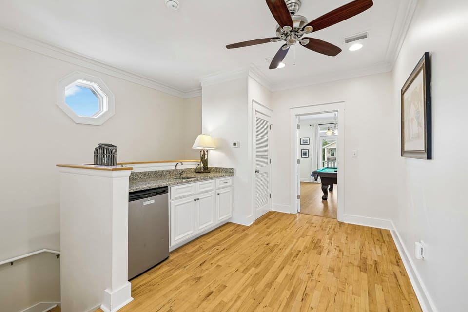 Your bright kitchenette features granite counters, modern appliances, and warm hardwood floors—perfect for whipping up morning coffee or evening snacks in this cozy, well-lit space.