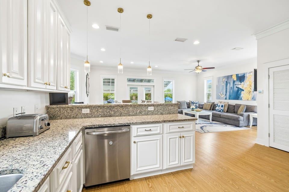 Your dream vacation space blends elegance and comfort—gleaming granite, stainless appliances, warm hardwood floors, and an inviting lounge under high ceilings with stylish pendant lights.