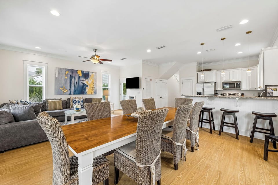Gather everyone in your bright, open living space where coastal charm meets modern comfort. Warm wood floors, stylish seating, and a fully-equipped kitchen set the stage for memorable meals and relaxed evenings together.