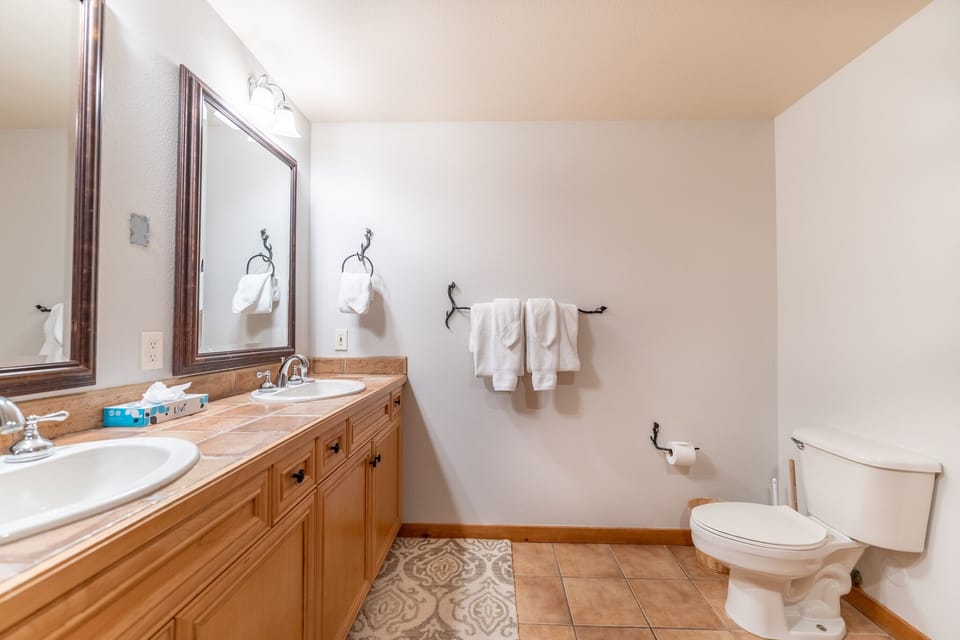 Your spacious bathroom features dual sinks and warm wood finishes, creating a welcoming space to start your day refreshed.