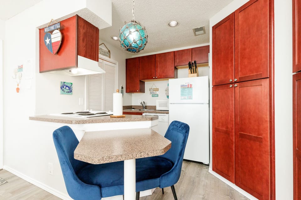 Your fully equipped kitchen features warm cherry cabinets, granite counters, and a cozy dining nook perfect for morning coffee or evening meals.