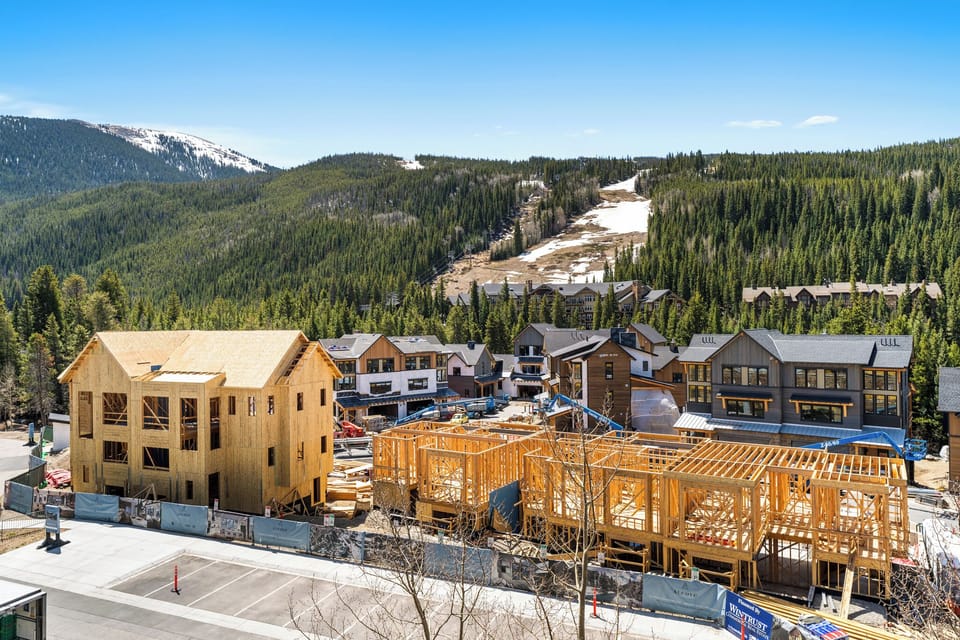 Mountain resort development with ski slopes and forested peaks creating a stunning alpine backdrop.