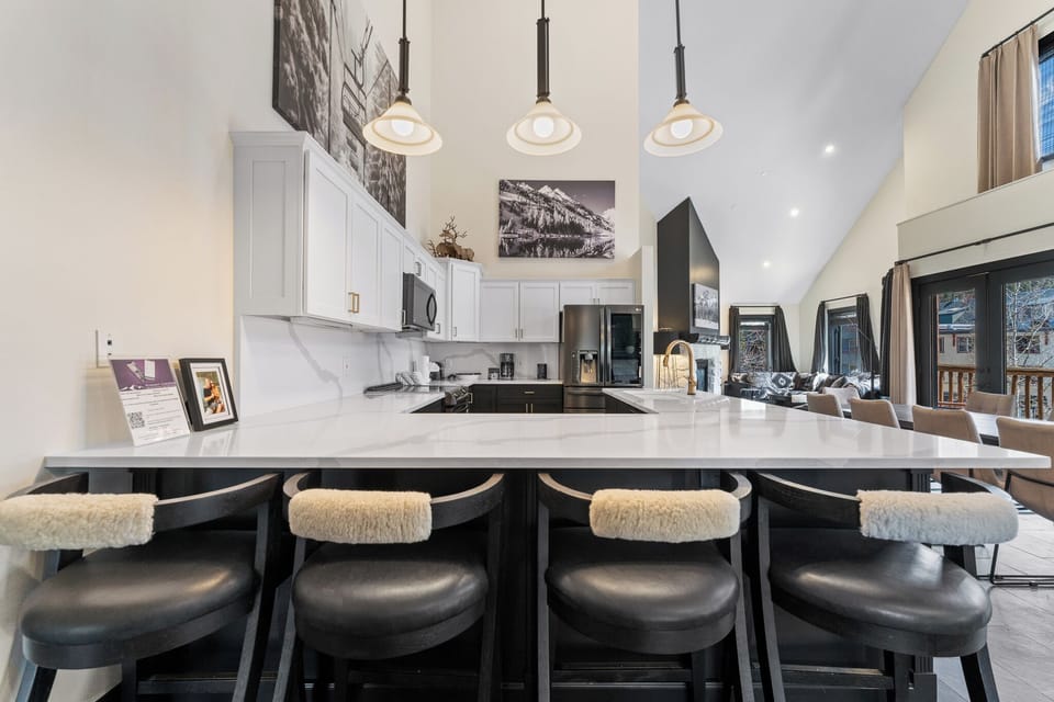 Your sleek kitchen island becomes the heart of your stay, where morning coffee and evening conversations flow beneath warm pendant lighting.