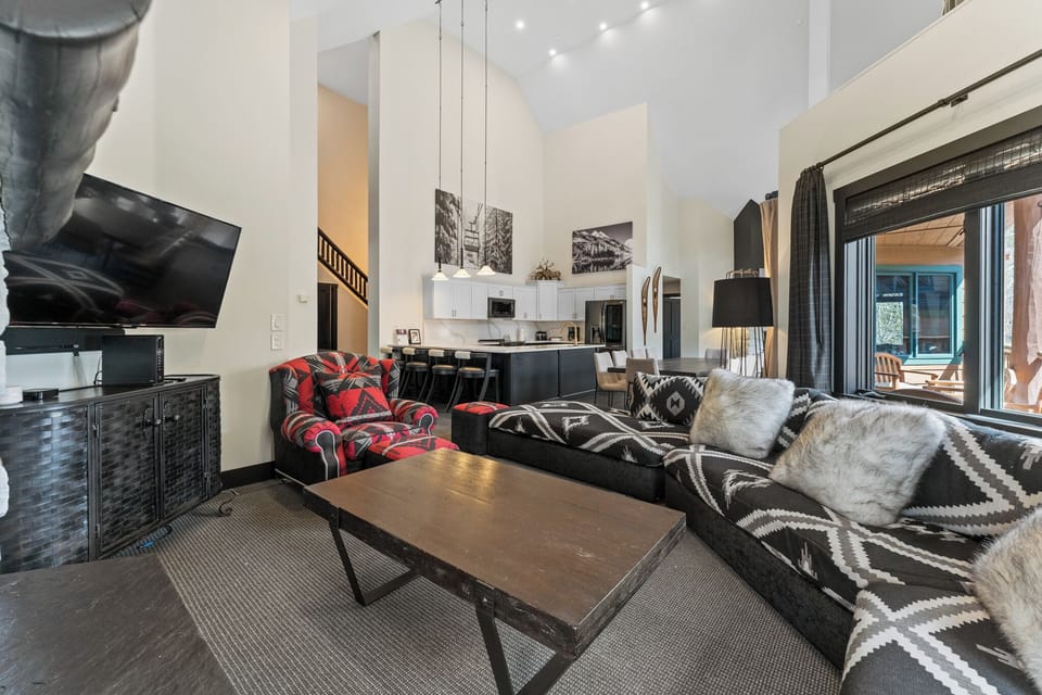 Unwind in your stylish living space with cozy sectional seating, modern entertainment center, and open-concept design flowing into the sleek kitchen.