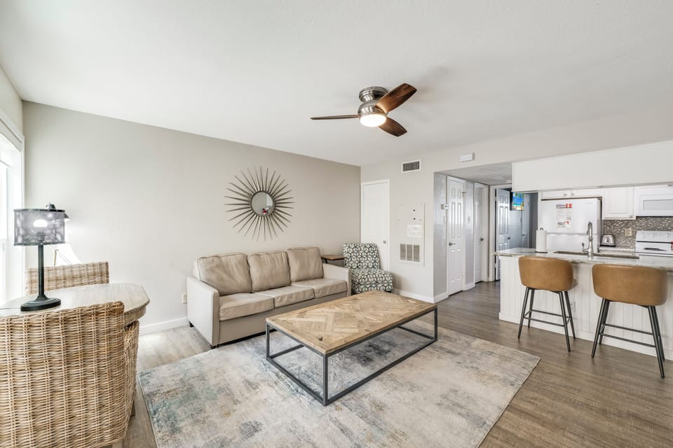 Unwind in your spacious open-concept living area that offers a sleeper sofa for extra sleeping, modern furnishings, and a ceiling fan create a calm, breezy atmosphere.