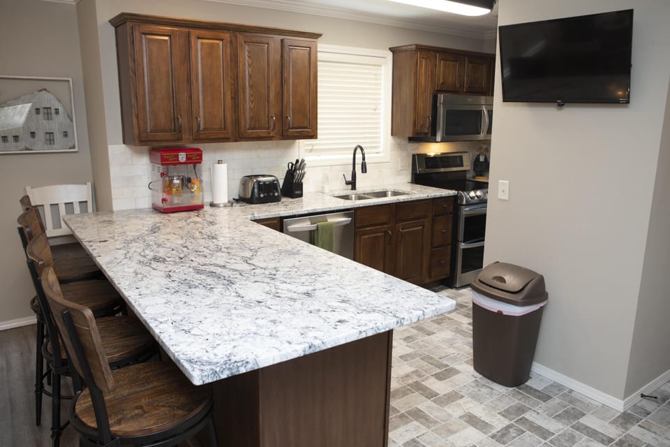 Four bar stools for kiddos while adults talk at the table. TV in the kitchen allows you to stay up with the game while your making coffee in the Keurig or grabbing a cold one!