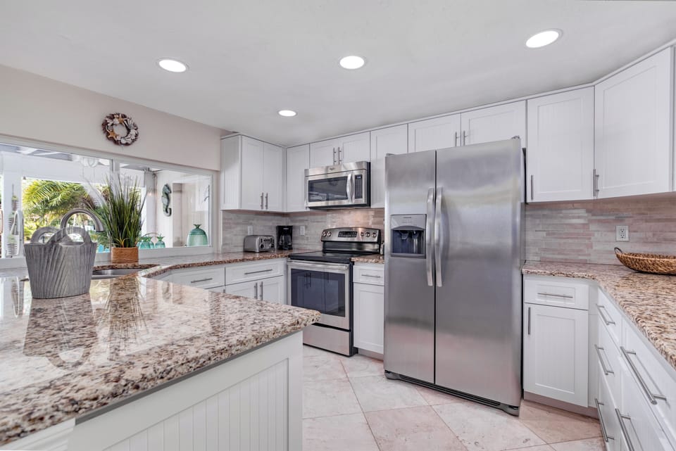 The sleek kitchen boasts stainless steel appliances, granite countertops, and everything you need to cook.