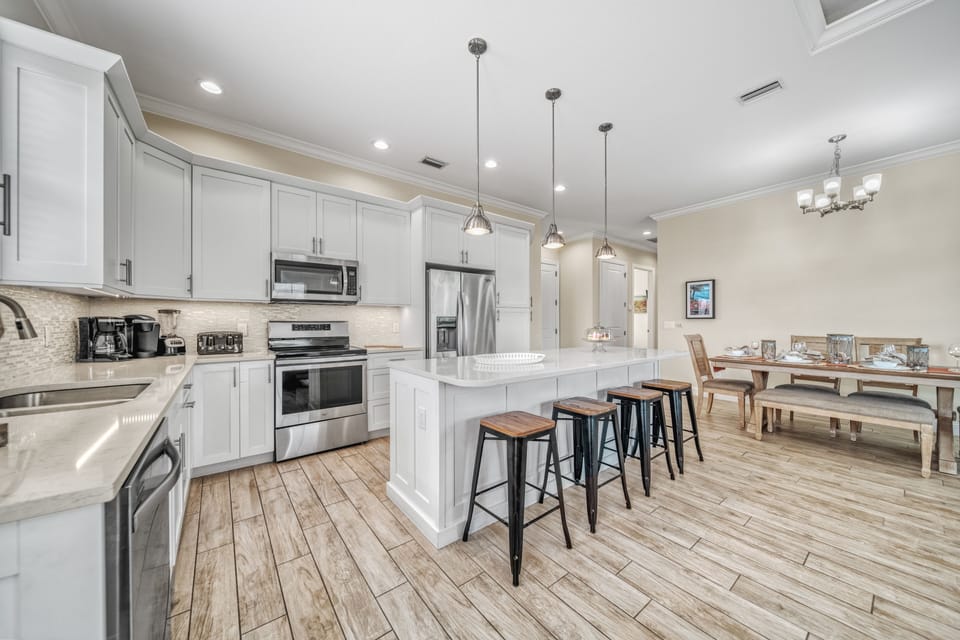 Polished quartz island with breakfast seating—where morning coffee and easy conversation begin each day.