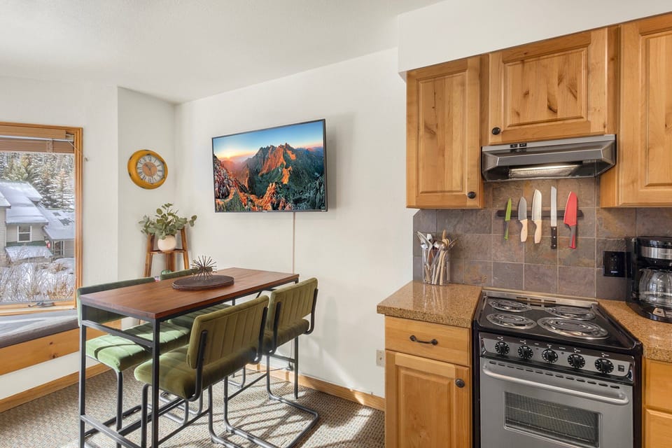 A compact kitchen fully equipped with everything you need—including a full fridge, oven, range, microwave, and dishwasher—for easy meal prep.