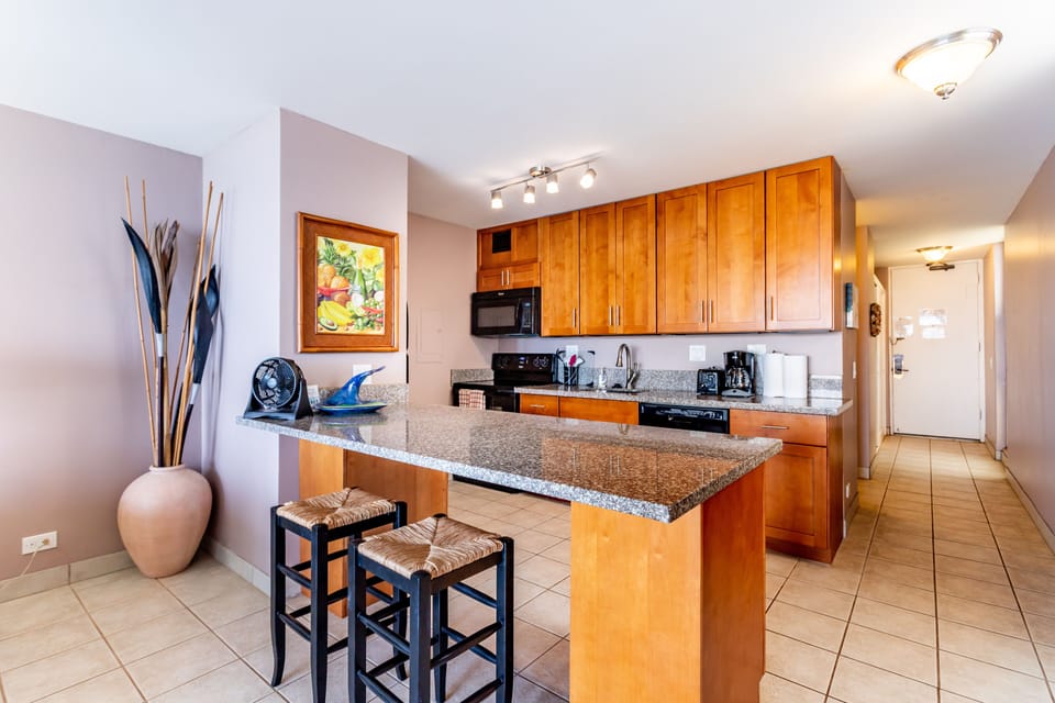 Your spacious kitchen welcomes you with warm wood cabinetry, granite countertops, and a breakfast bar—perfect for preparing meals or enjoying morning coffee in style.