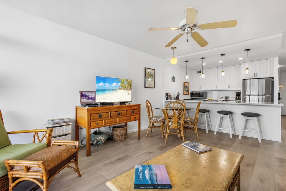 Step into your open-concept living space with airy ceilings, a fully equipped kitchen, and cozy dining—perfect for unwinding after beach days.