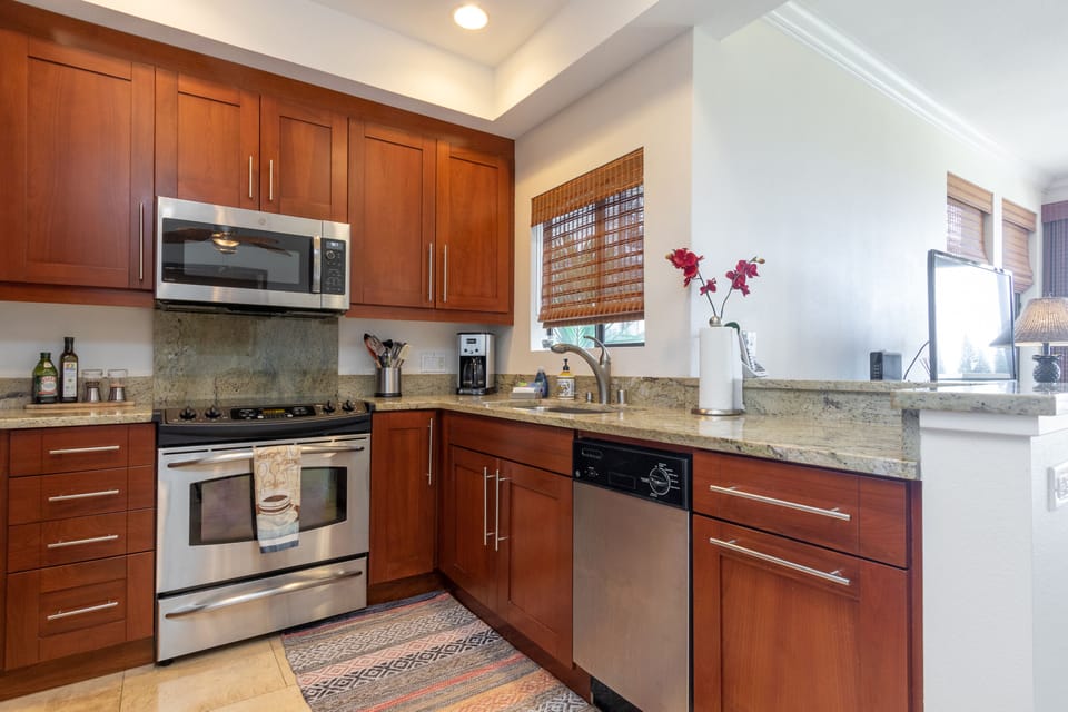 Your fully-equipped kitchen features rich wood cabinetry, granite counters, stainless steel appliances, and a coffee maker—perfect for whipping up meals or enjoying a morning brew.